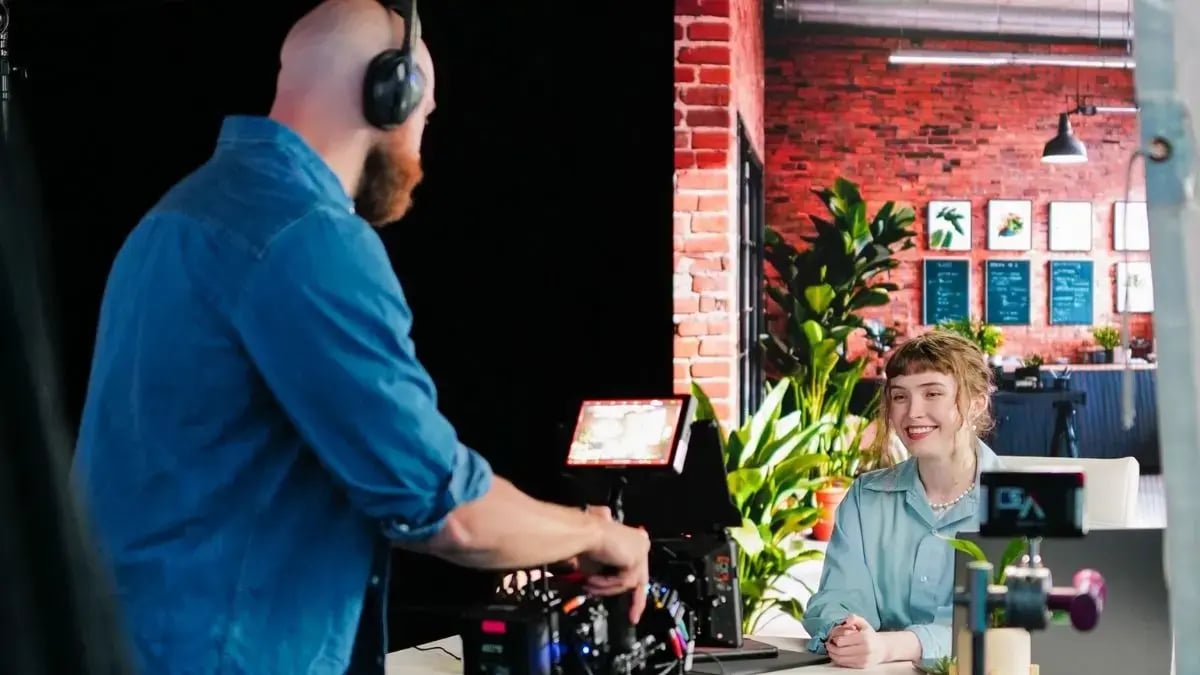 woman at desk being filmed